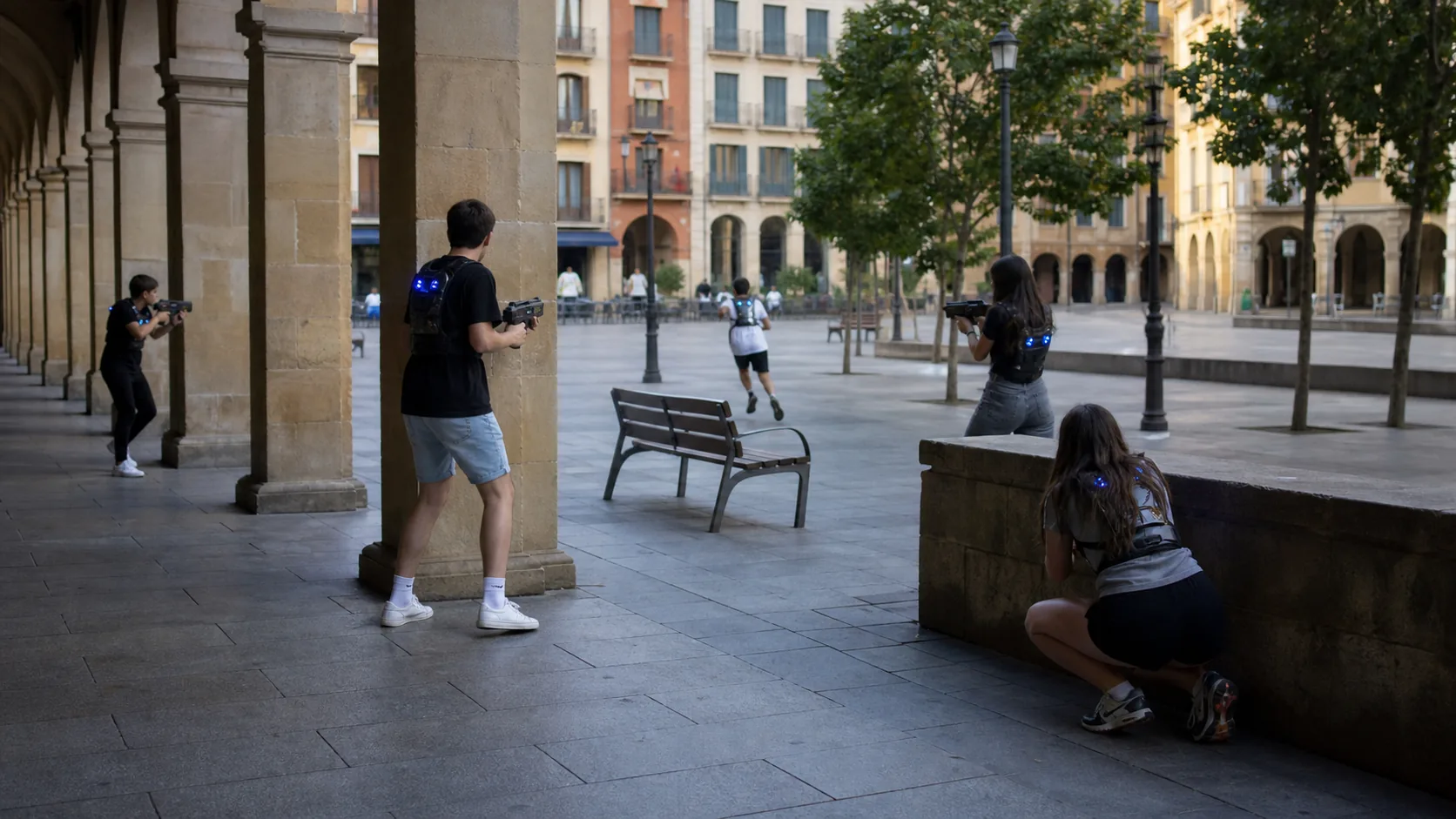 Adolescentes jugando laser tag movil en una plaza de Pamplona